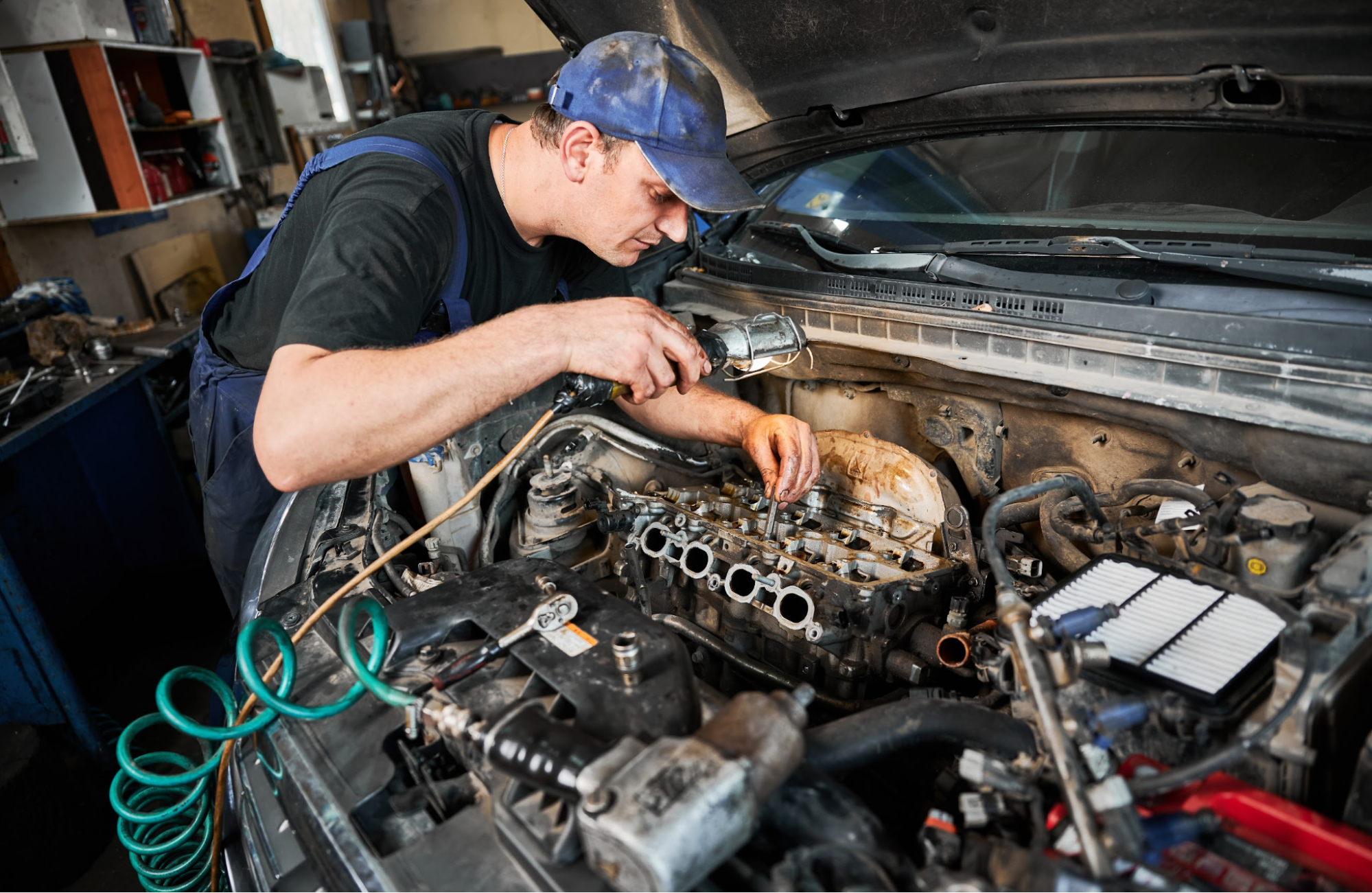 A man looking under the hood of a car