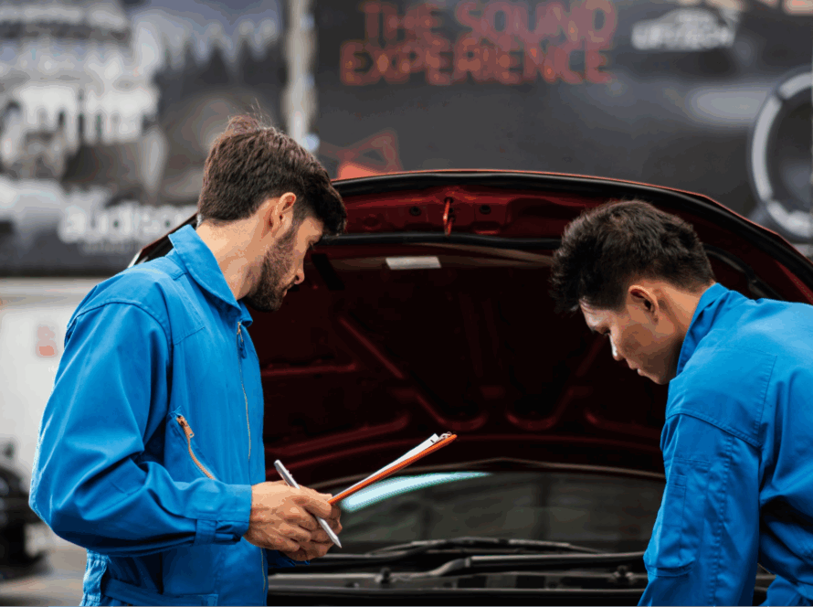Two mechanics looking under the hood of a car