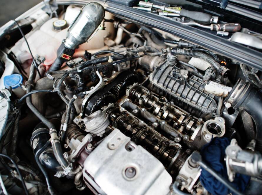 A close-up view of a newly rebuilt engine fully installed in a car, showcasing clean components and precision craftsmanship.