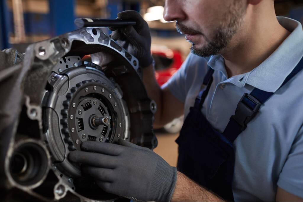 A mechanic fixing a car’s clutch during a replacement service.