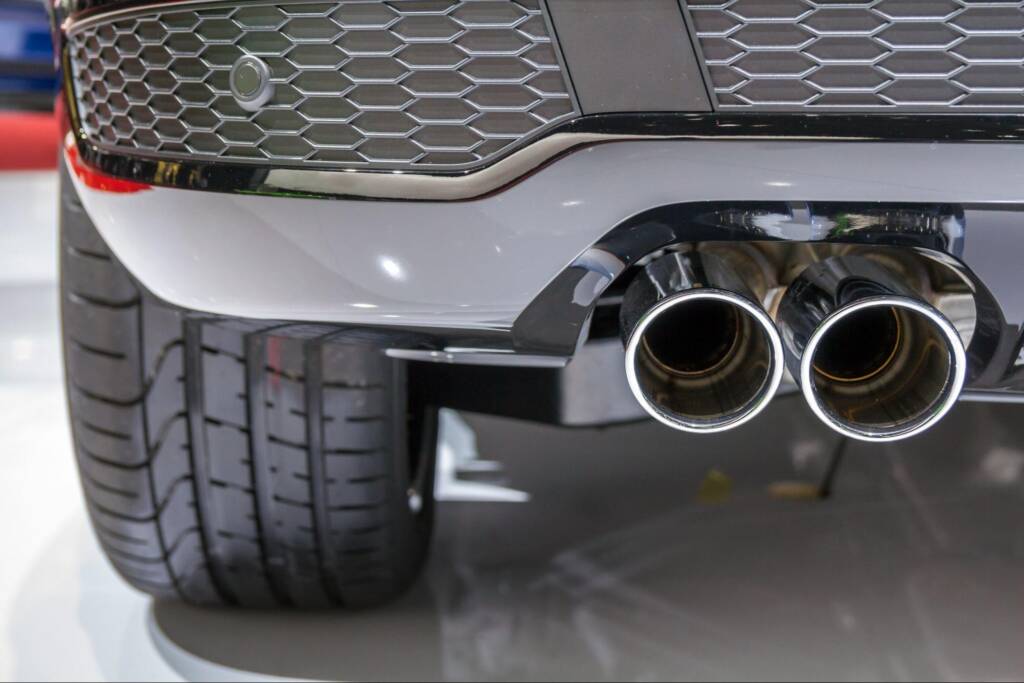 Performance exhaust system with twin chrome pipes and grey plastic details